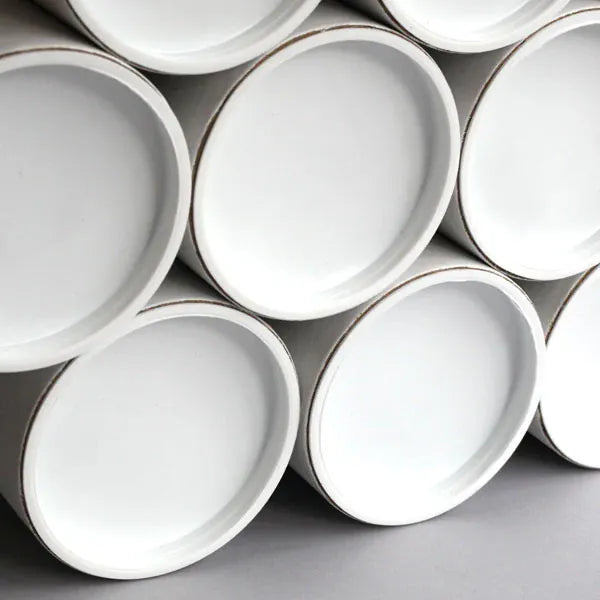 Stack of white packing tubes on a gray background