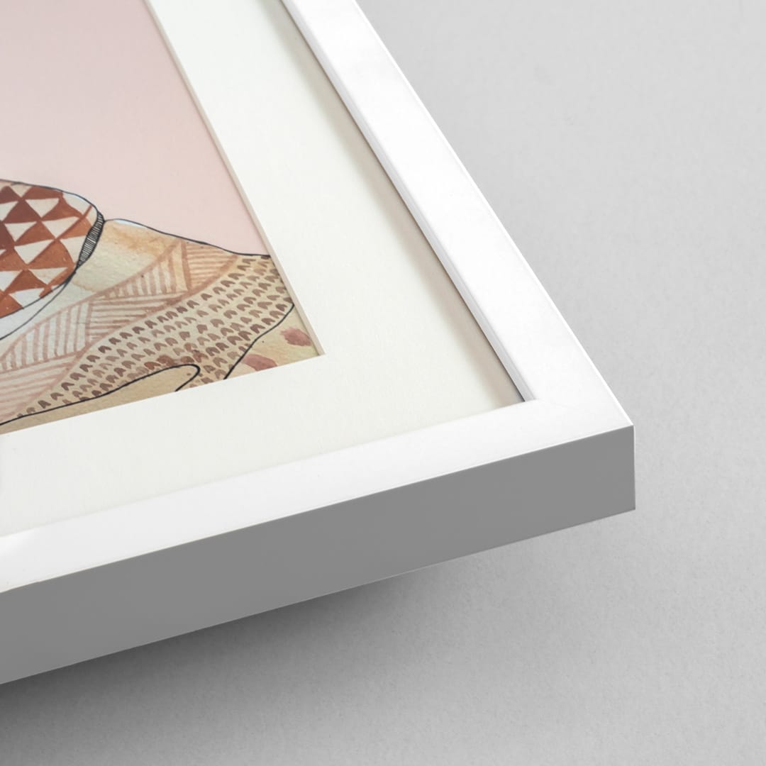 Close-up of a white picture frame with a white mat, showing part of a pastel art print on a light gray background.