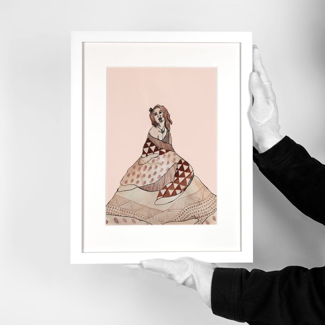 A framed art print featuring a stylized illustration of a Maori woman in a patterned dress on a pale pink background.